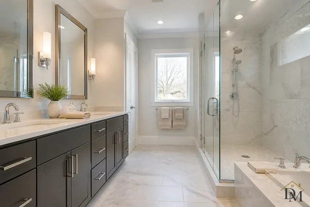 Bathroom with a dark double vanity, mirrors, glass shower and tub; sinks, fixtures, mirrors and floors are part of every house-cleaning visit.